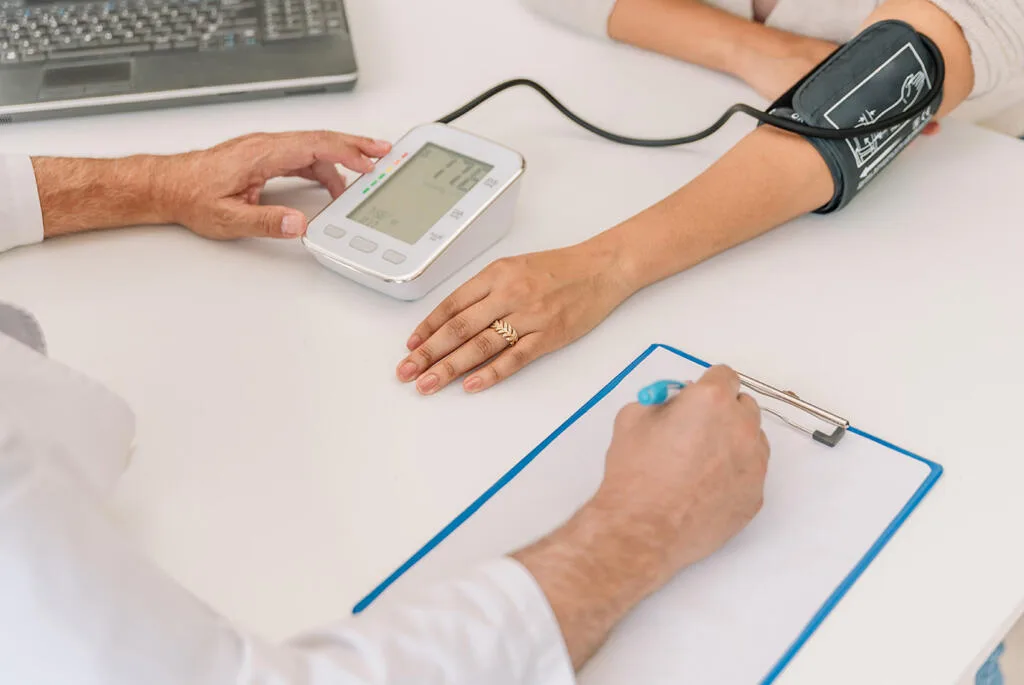 Helpful Pharmacist taking blood pressure check in Huddersfield at Park View Pharmacy.