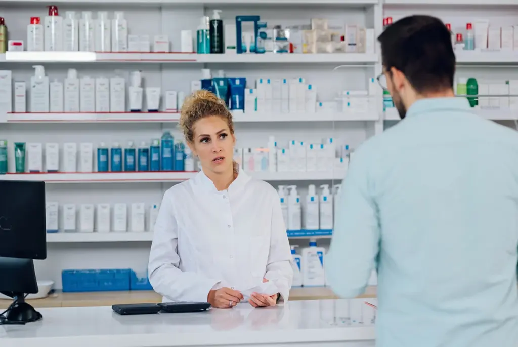 Pharmacist explaining NHS Pharmacy First Services to a customer at Park View Pharmacy in Huddersfield.